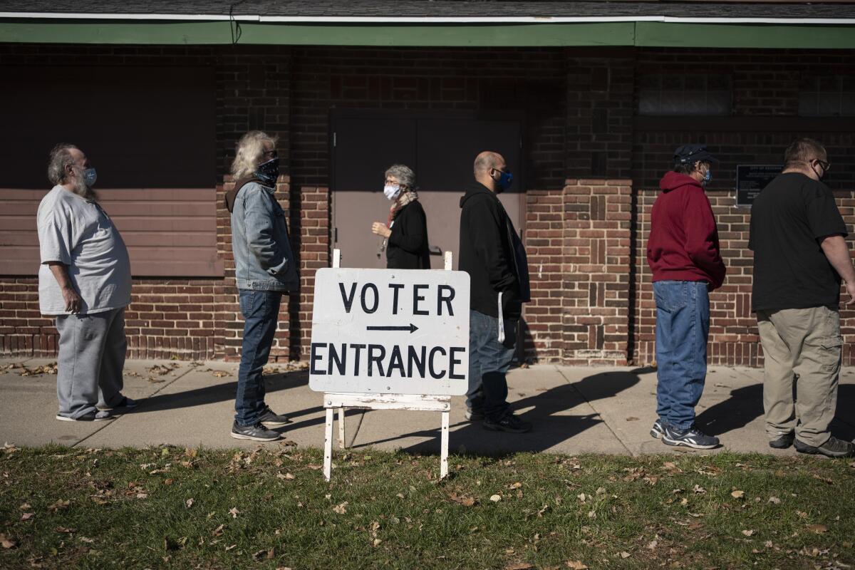 FILE - In this Tuesday, Nov. 3, 2020, file photo, voters wait in line outside a polling center on Election Day, in Kenosha, Wis. Posts shared thousands of times on Facebook, Twitter and Instagram are falsely claiming that an impossible number of people cast ballots in Wisconsin. Meagan Wolfe, the state’s top elections official, addressed the social media rumors Thursday, Nov. 5, saying: “Wisconsin does not have more votes than registered voters.” (AP Photo/Wong Maye-E, File)