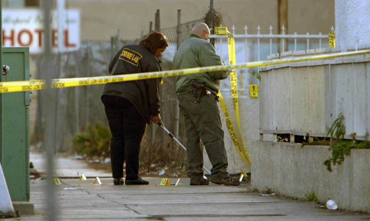 Authorities work at the scene of a shooting near Hollywood Park in Inglewood that left one suspect dead and two sheriff's deputies injured.