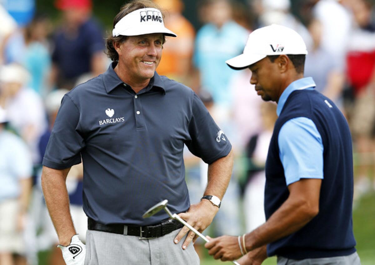 Phil Mickelson was all smiles after making a birdie at No. 11 while playing partner Tiger Woods was struggling in the first round of the Deutsche Bank Championship on Friday at TPC Boston.