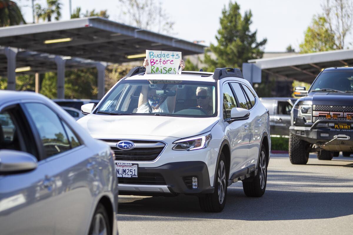 Residents participate in a drive-by parade outside of Huntington Beach City Hall on Monday to protest a vote on union raise agreements.