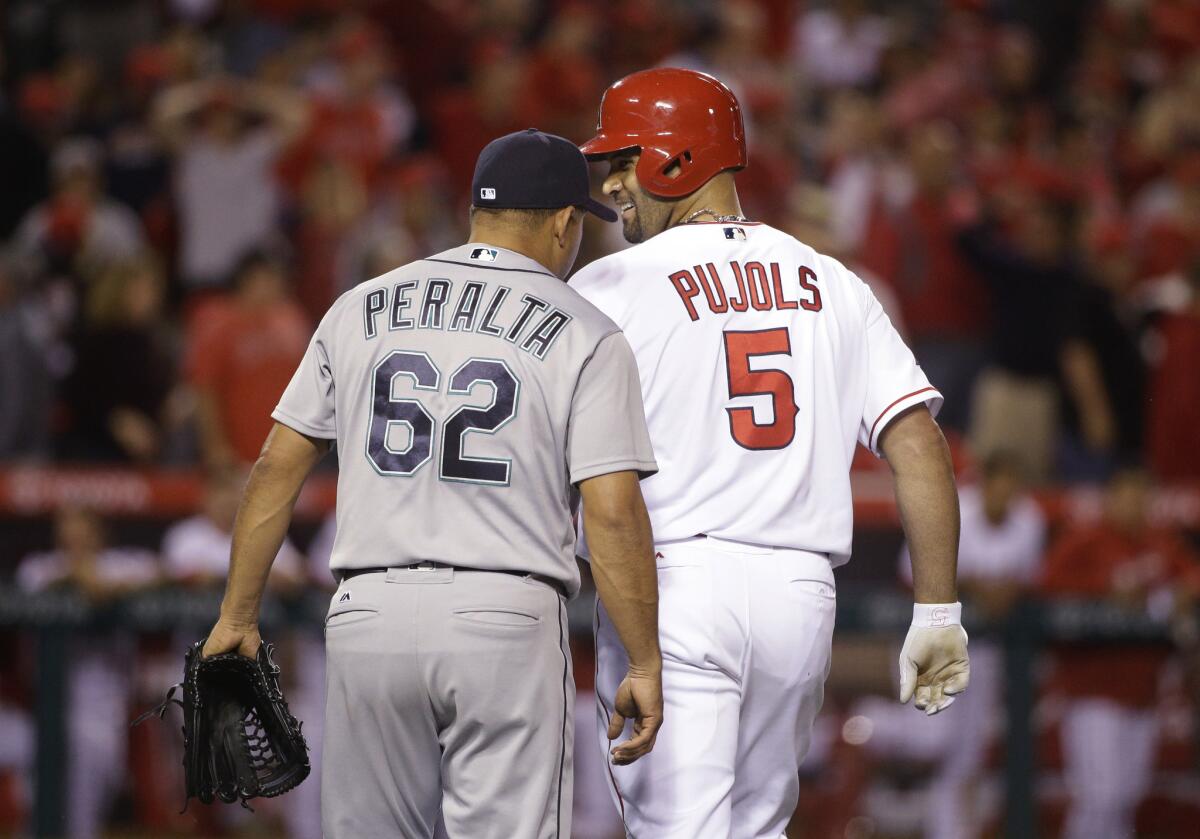 Albert Pujols smiles at Mariners relief pitcher Joel Peralta after flying out during the ninth inning of a game on April 22.