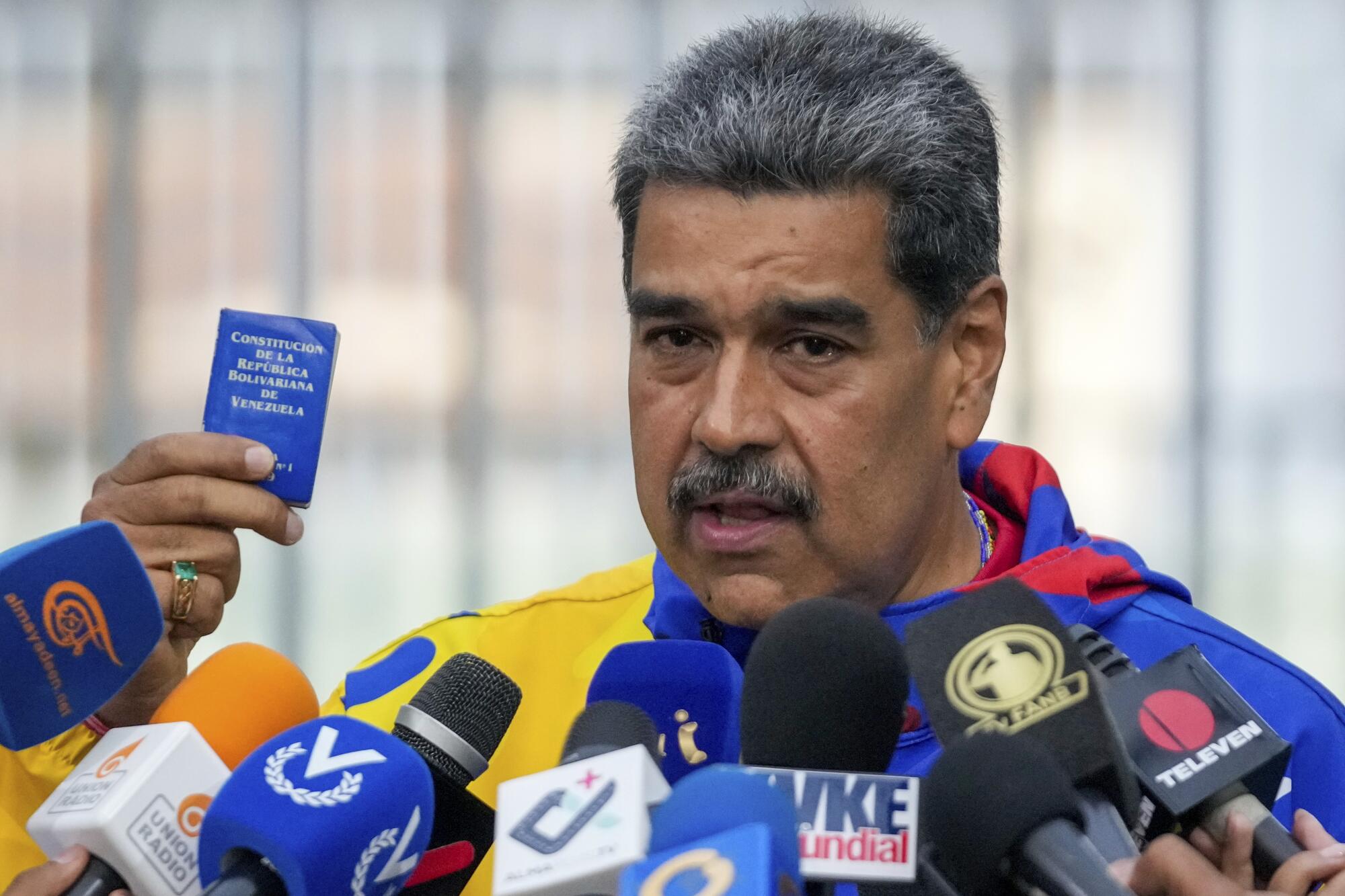 El presidente Nicolás Maduro muestra una edición en miniatura de la Constitución 