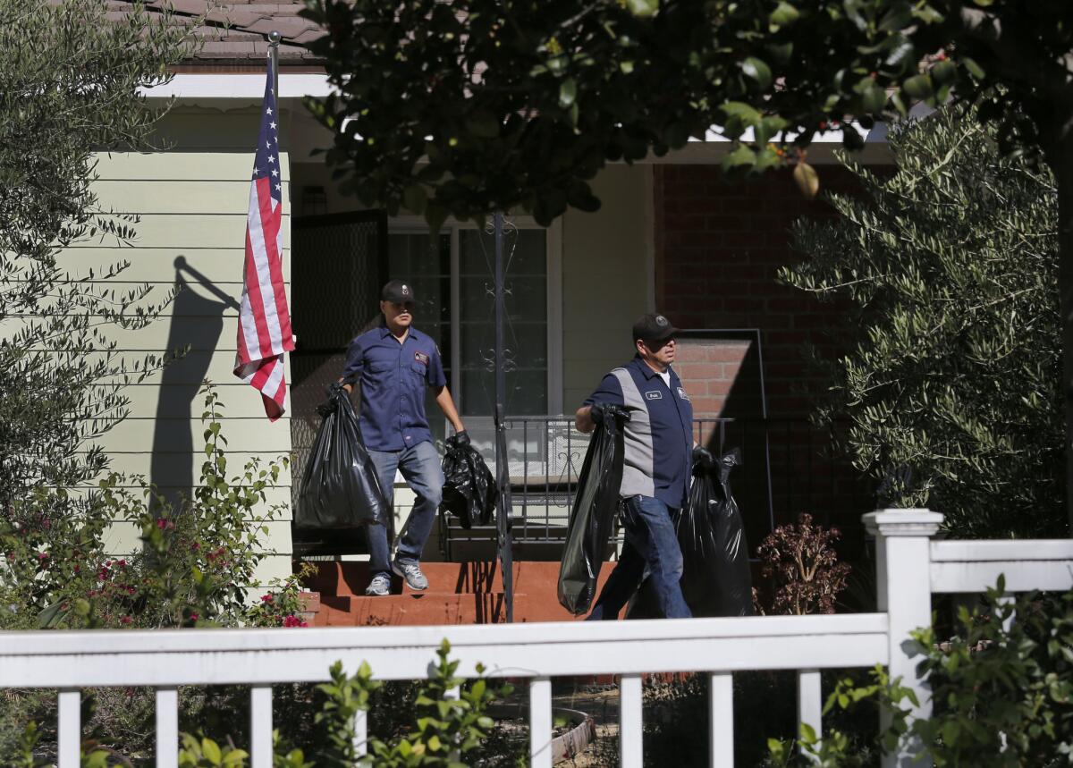 Police investigators and an Emergency Response crew clean up a house in La Cañada-Flintridge Monday morning, where an apparent murder/suicide took place on Sunday night.