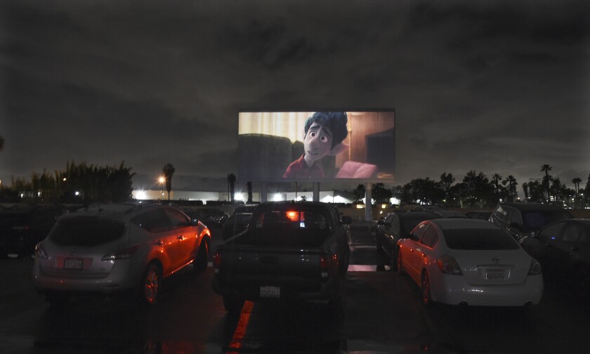 Viewers in parked cars watch the animated film "Onward" at the Paramount Drive-In Theatres, Thursday, March 19, 2020, in Paramount, Calif. The drive-in theater, long a dwindling nostalgia act in a multiplex world, is experiencing a momentary return to prominence. With nearly all of the nation’s movie theaters shuttered due to the pandemic, some drive-in owners think they’re in a unique position to give moviegoers a chance to do something out of the house but stay within prudent distance from one another. (AP Photo/Chris Pizzello)
