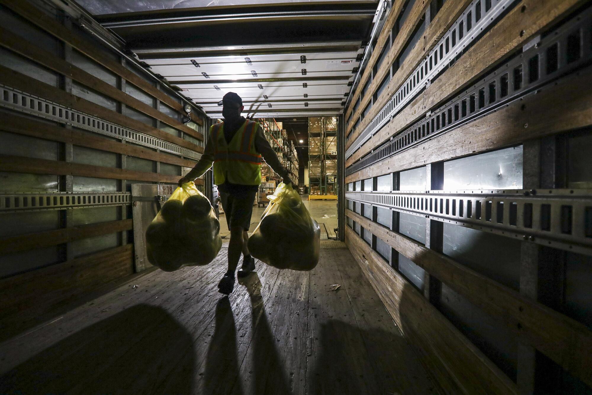 Jesus Carrillo loads basketballs to be distributed with meal bags to children at the LAUSD Procurement Services Center in Pico Rivera.