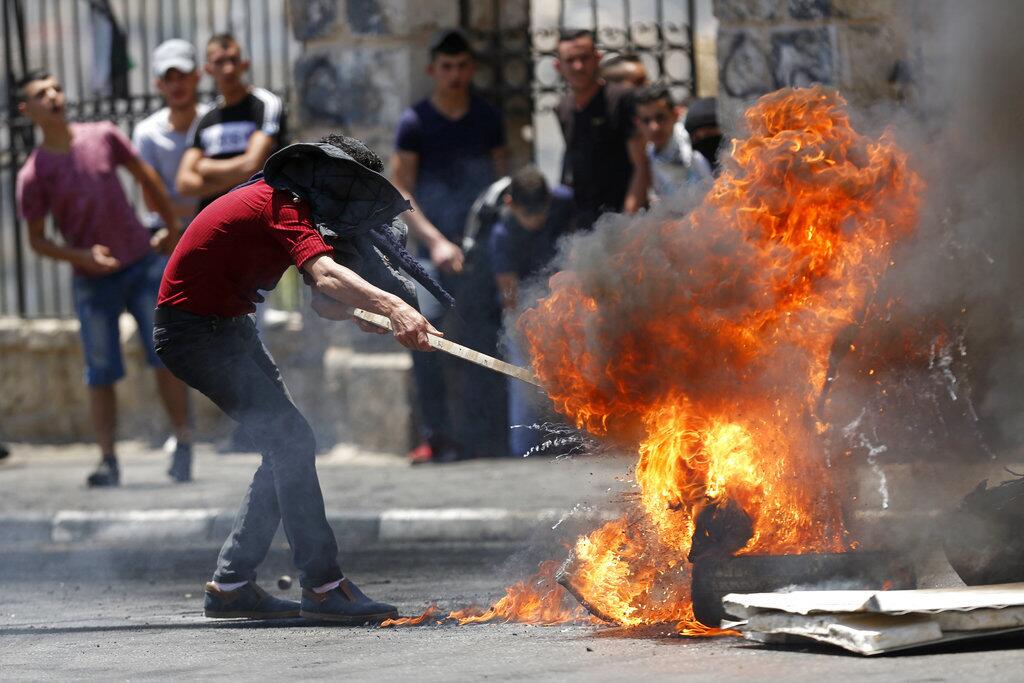 Palestinians burn tires during clashes with Israeli forces after a rally to mark the 70th anniversary of what Palestinians call their "nakba," or catastrophe â€” the uprooting of hundreds of thousands in the Mideast war over Israel's 1948 creation, in the West Bank city of Bethlehem, Tuesday, May 15, 2018.