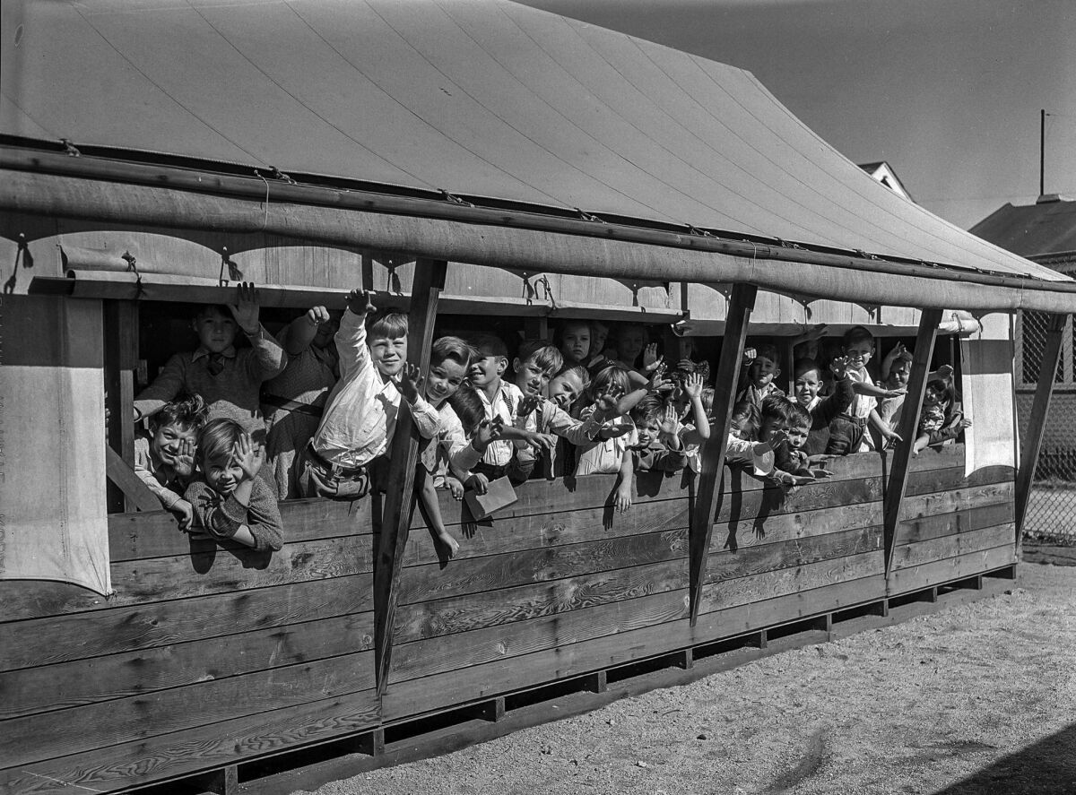 Nov. 17, 1935: Fourth-graders at 61st Street School wave from the window of their tent classroom. Voters passed a measure on Nov. 19, 1935, to upgrade school buildings.