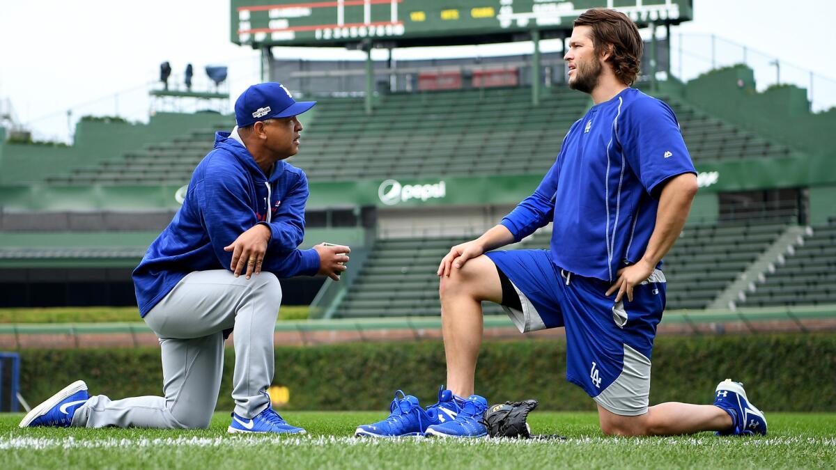 Dodgers Manager Dave Roberts chats with ace Clayton Kershaw before Game 1 of the NLCS in Chicago on Saturday.