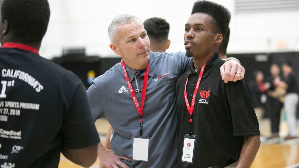 Keith Jones of ABC Medical, left, talks with Ahkeel Whitehead of Aztec Adaptive Sports during a demonstration of adaptive sports at SDSU's Peterson Gym on Saturday.