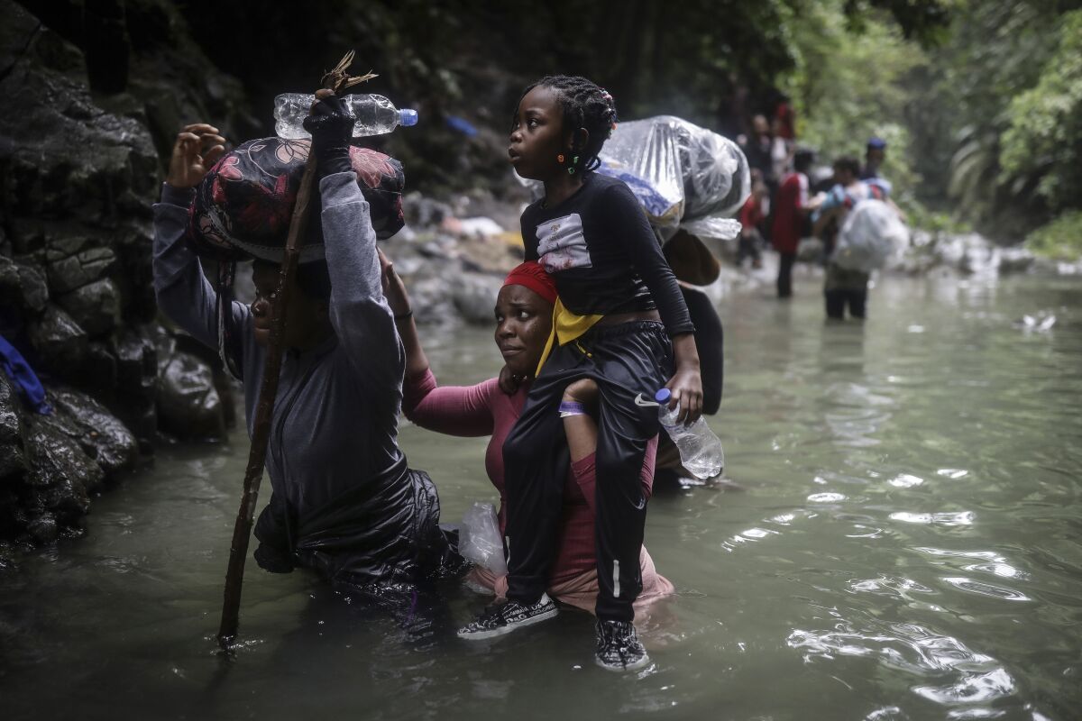 FILE - Haitian migrants wade through water as they cross the Darien Gap from Colombia to Panama in hopes of reaching the U.S., May 9, 2023. Hundreds of thousands of migrants have risked the dangerous trek through the jungle in recent years and the flow this year is on a record pace. (AP Photo/Ivan Valencia, File)