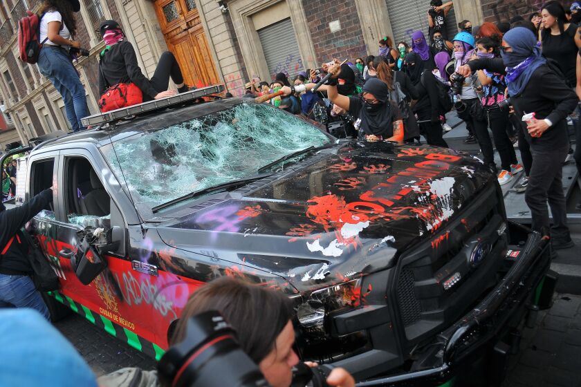 Demonstrators smash a car during a march to commemorate the International Women's Day, in Mexico City on Sunday.