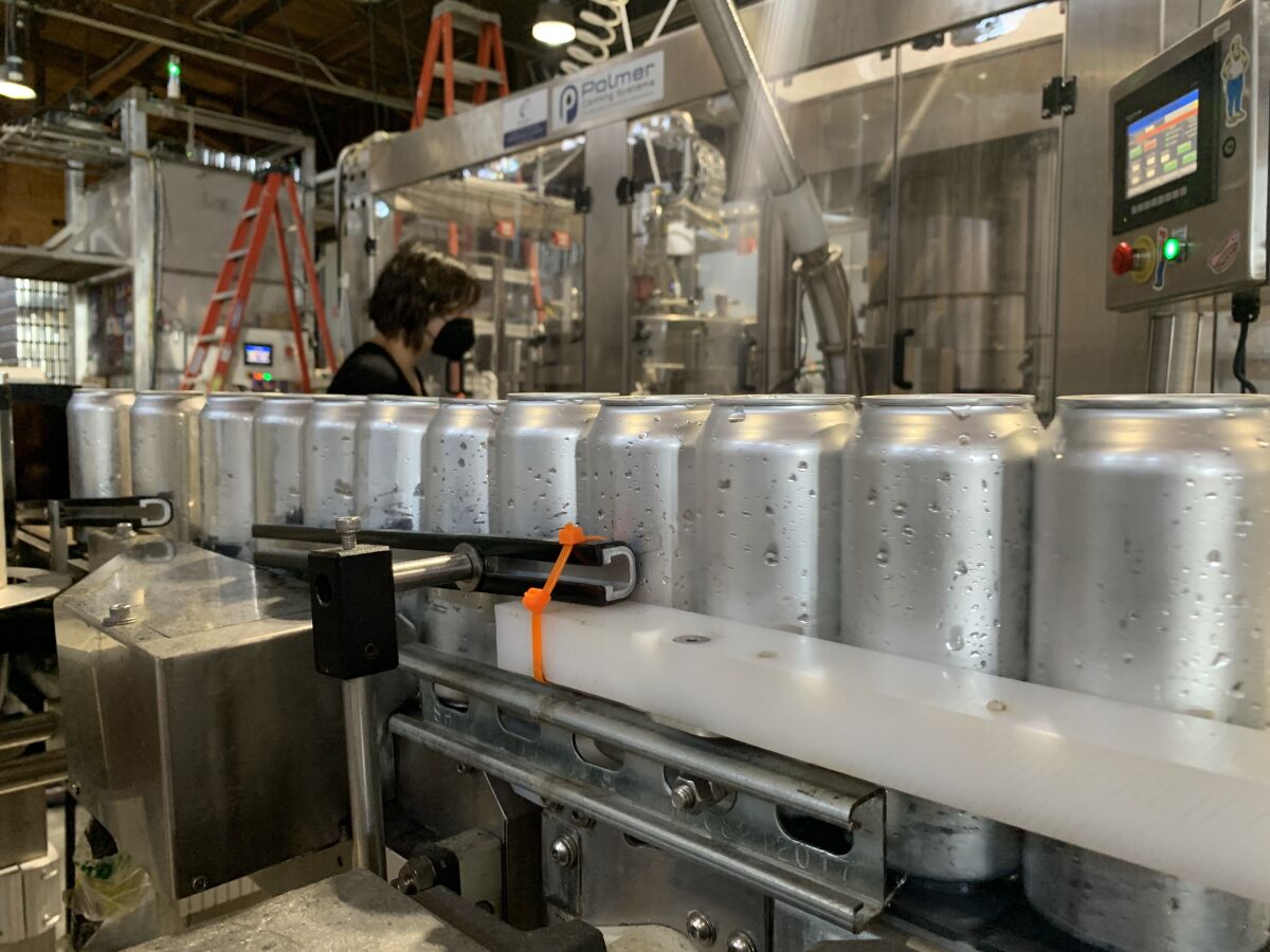 Aluminum cans make their way down the canning line at Almanac Beer Co. in Alameda, Calif. 