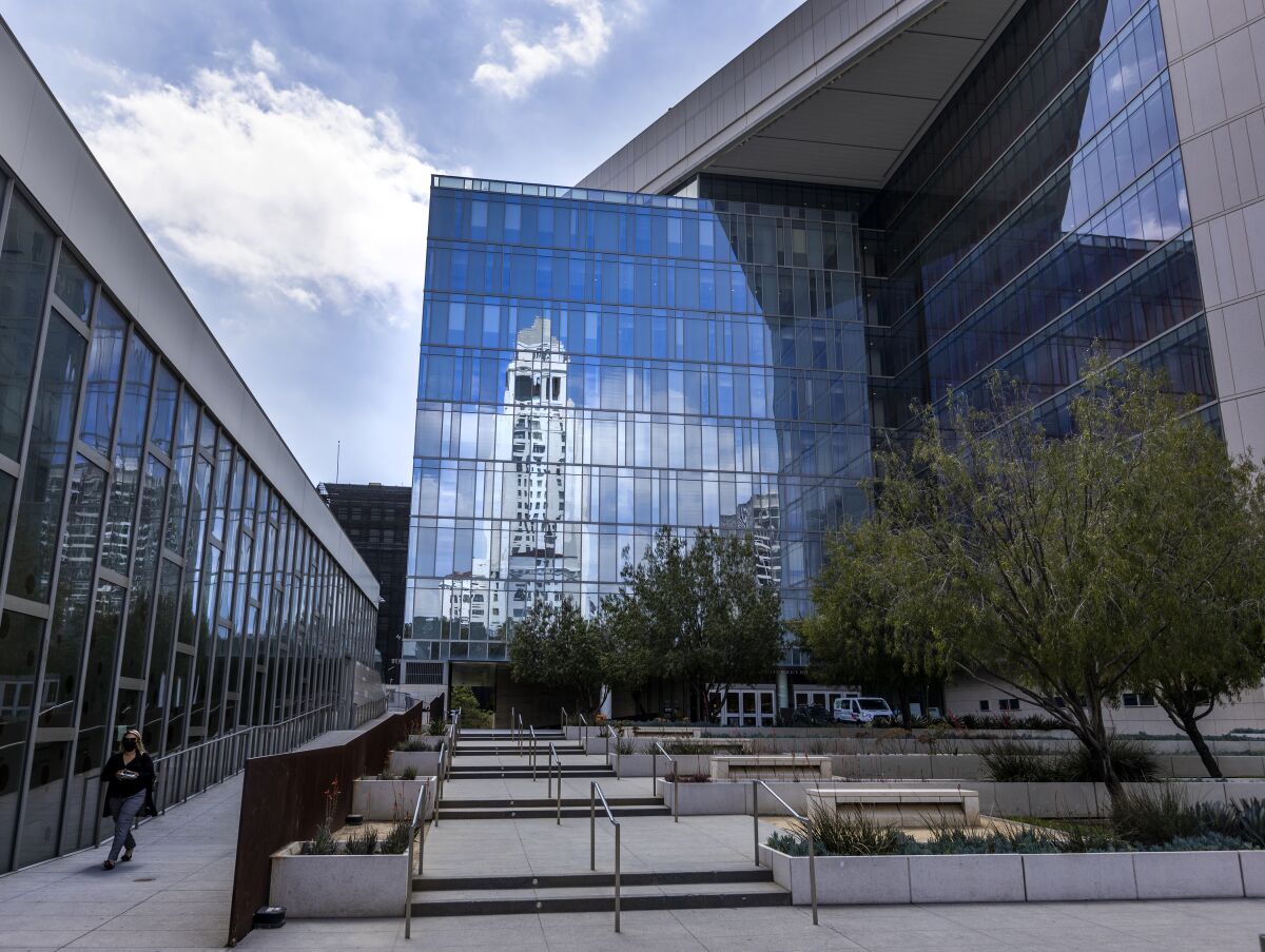 Los Angeles City Hall is reflected in the windows of the Los Angeles Police Headquarters