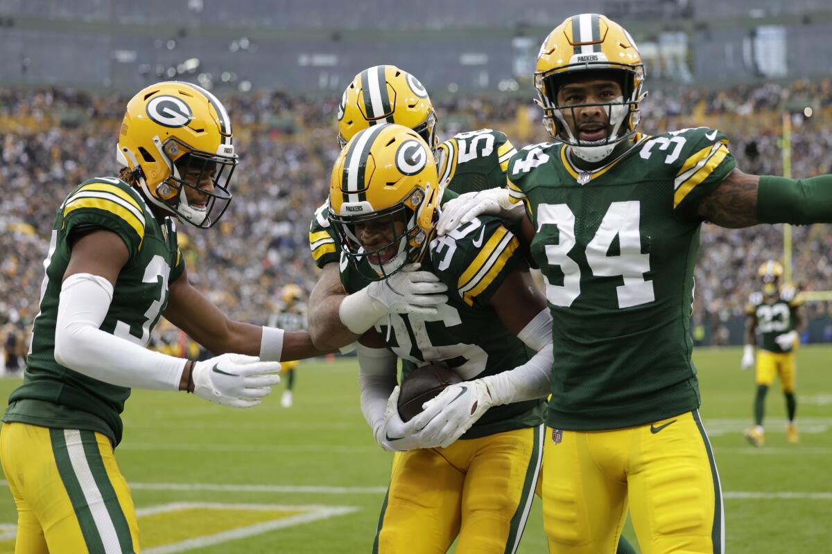 Packers safety Anthony Johnson Jr. (36) celebrates with teammates after intercepting a pass during the second half.