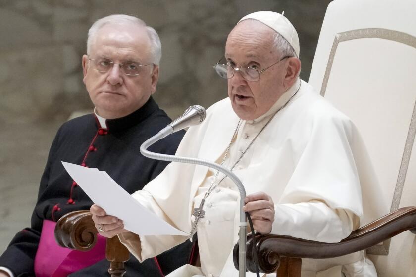 Pope Francis, right, flanked by Father Leonardo Sapienza, left, delivers his speech during his weekly general audience in the Pope Paul VI hall at the Vatican, Wednesday, Aug. 30, 2023. (AP Photo/Andrew Medichini)