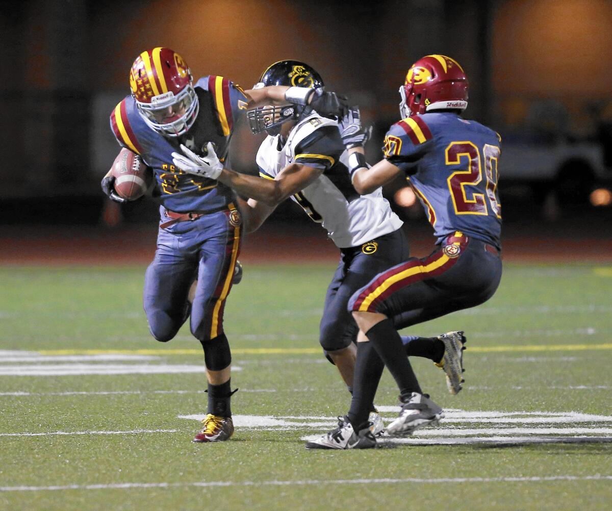 Estancia High's Trevor Brown fends off Christopher Zotea of Godinez after an interception in the first half.