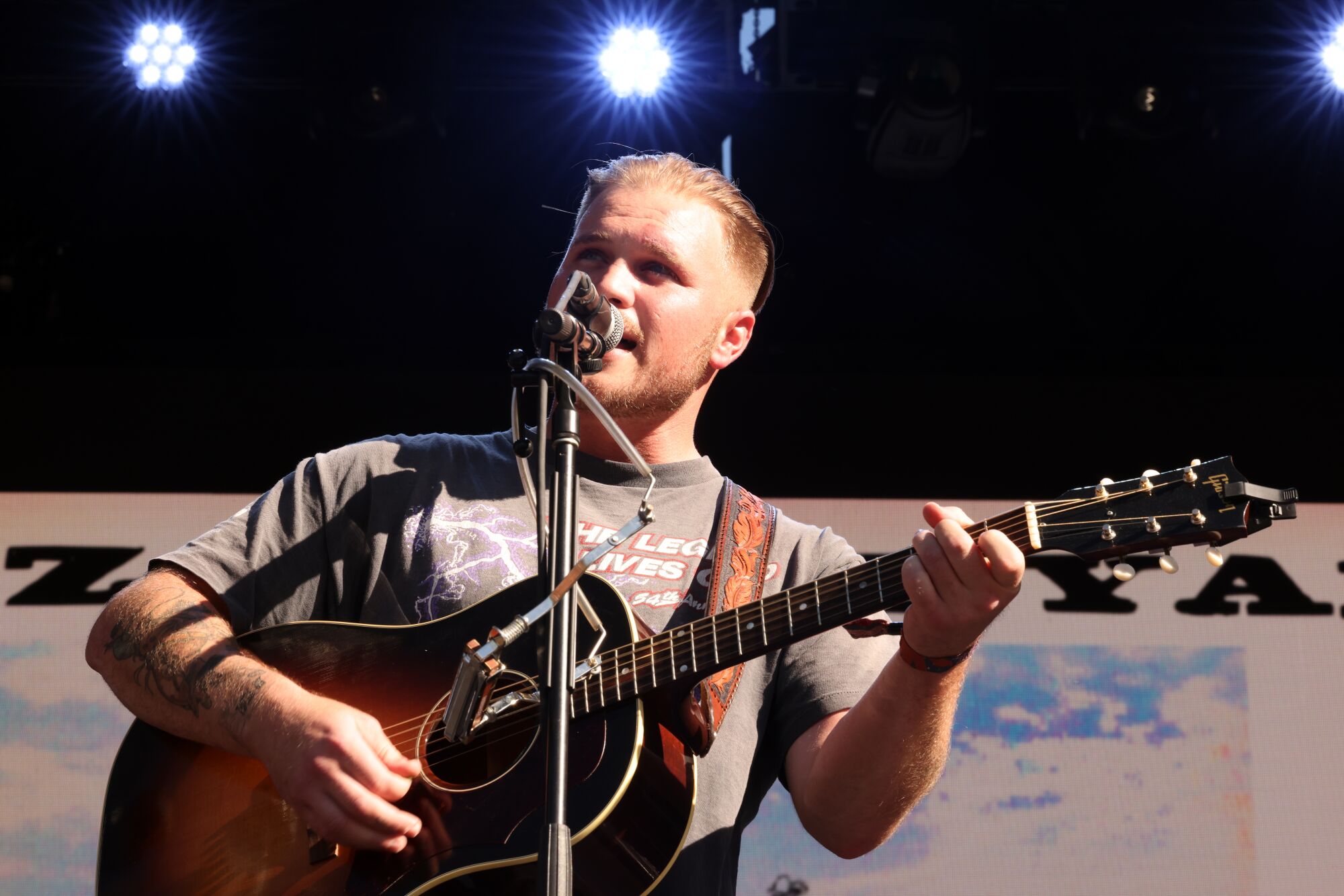 A country singer performs onstage with an acoustic guitar