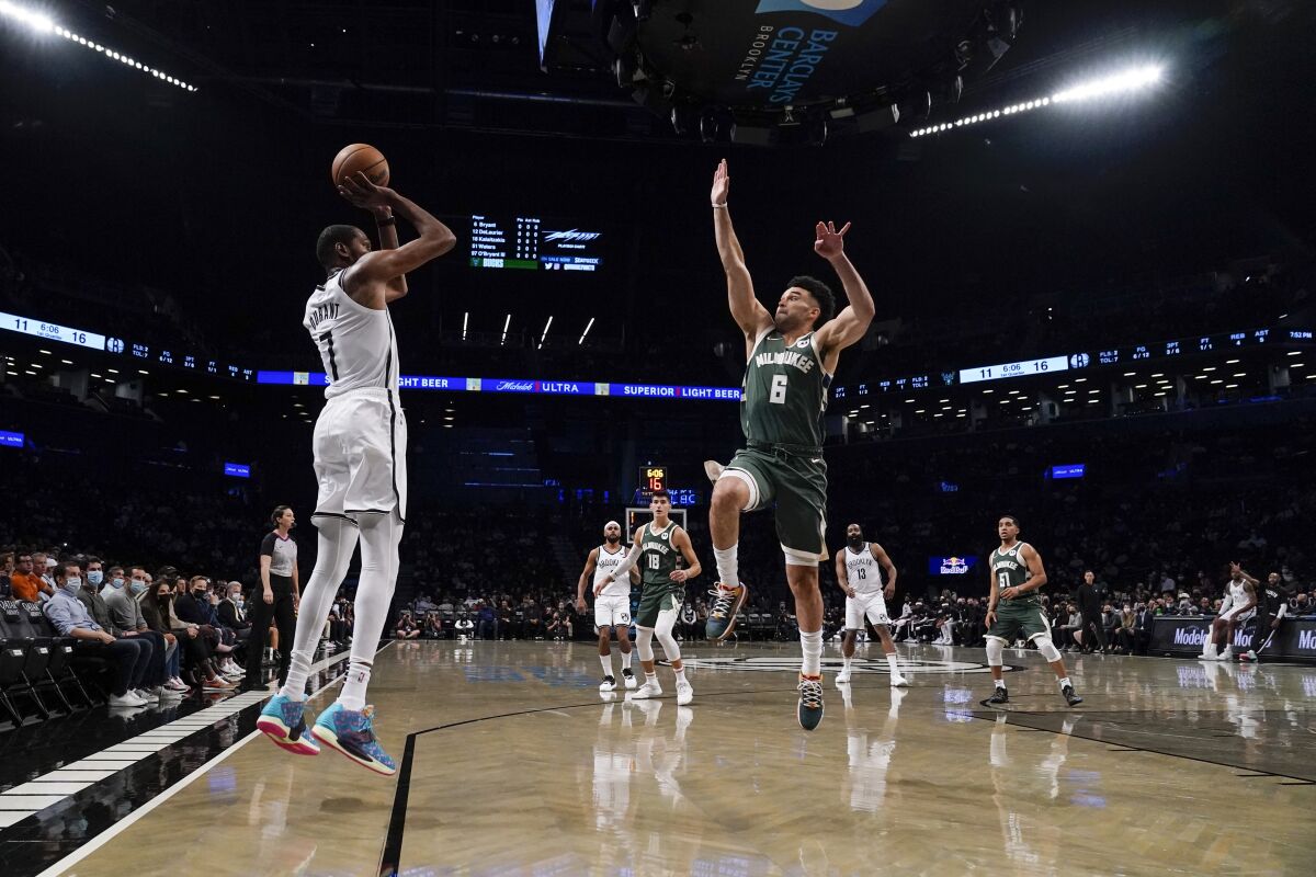Brooklyn Nets' Kevin Durant (7) shoots over Milwaukee Bucks' Elijah Bryant (6) during the first half of a preseason NBA basketball game Friday, Oct. 8, 2021, in New York. (AP Photo/Frank Franklin II)