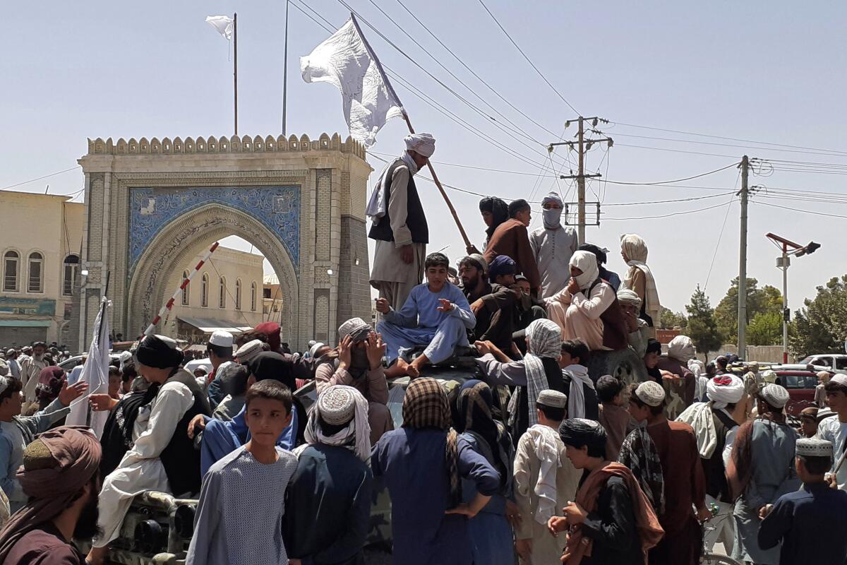 People crowd onto and surround a vehicle in the street