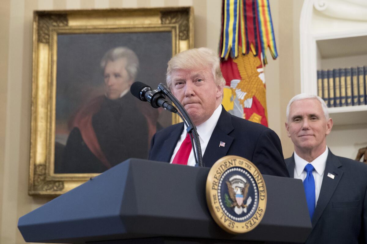 A portrait of former President Jackson hangs on the wall behind President Trump, accompanied by Vice President Mike Pence, as he speaks in the Oval Office on March 31.