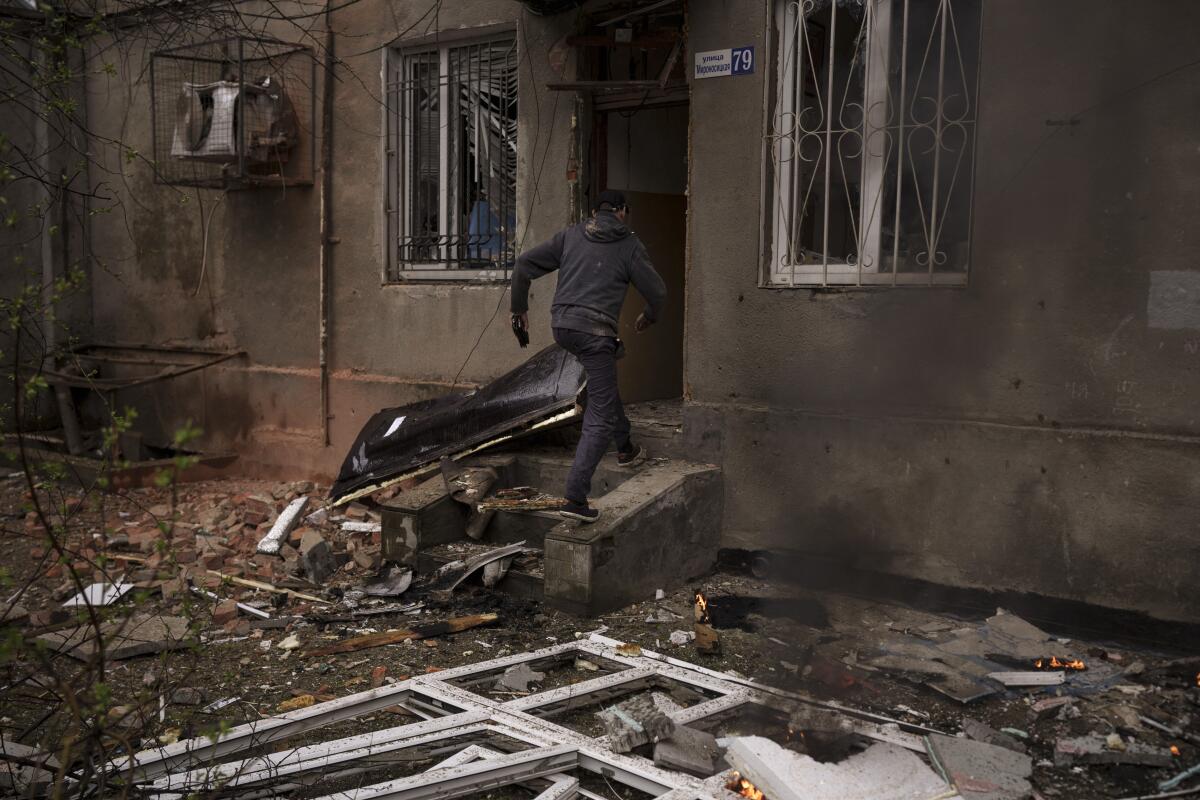 Un hombre ingresa a su edificio incendiado luego de un ataque ruso