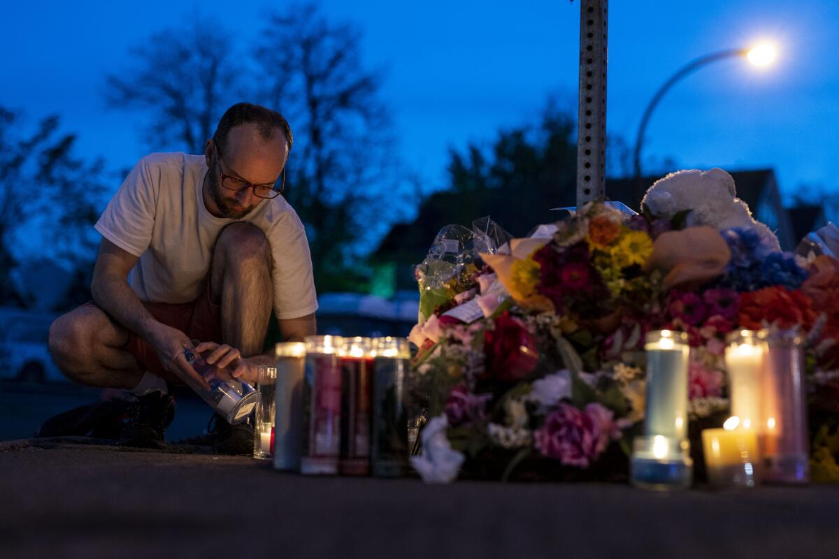 A man lights candles at a makeshift memorial at Tops Friendly Markets in Buffalo, N.Y.