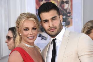 Britney Spears and Sam Asghari pose together for cameras at a red-carpet event