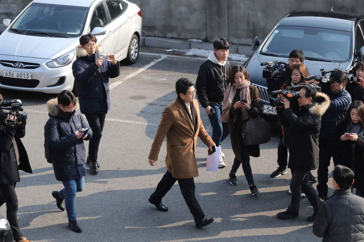 Journalists surround a prosecutor attempting to enter the presidential Blue House in Seoul on Feb. 3, 2017.