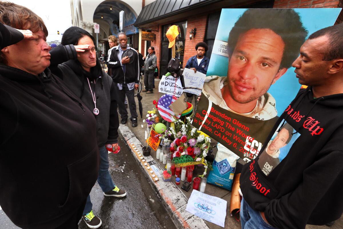 Cookie Marie Genovese and Heather Genovese salute a photograph of their friend Brendon Glenn.