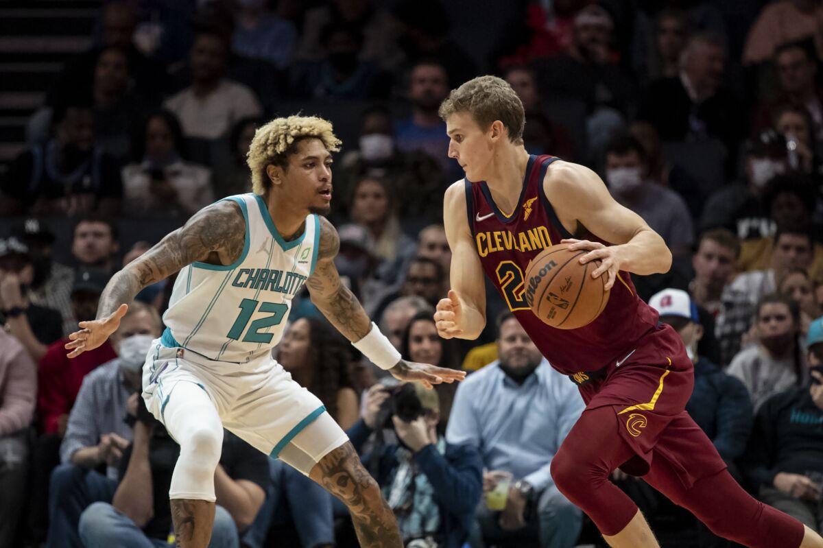 Charlotte Hornets guard Kelly Oubre Jr. (12) defends Cleveland Cavaliers forward Lauri Markkanen (24) during the first half of an NBA basketball game, Monday, Nov. 1, 2021, in Charlotte, N.C. (AP Photo/Matt Kelley)