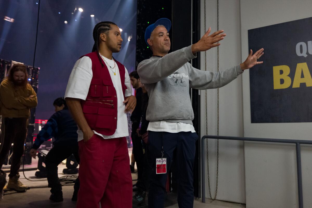 Two men stand on the set of "Neon."