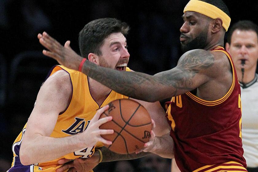 Lakers forward Ryan Kelly looks for room to maneuver against Cleveland's LeBron James on Jan. 15.