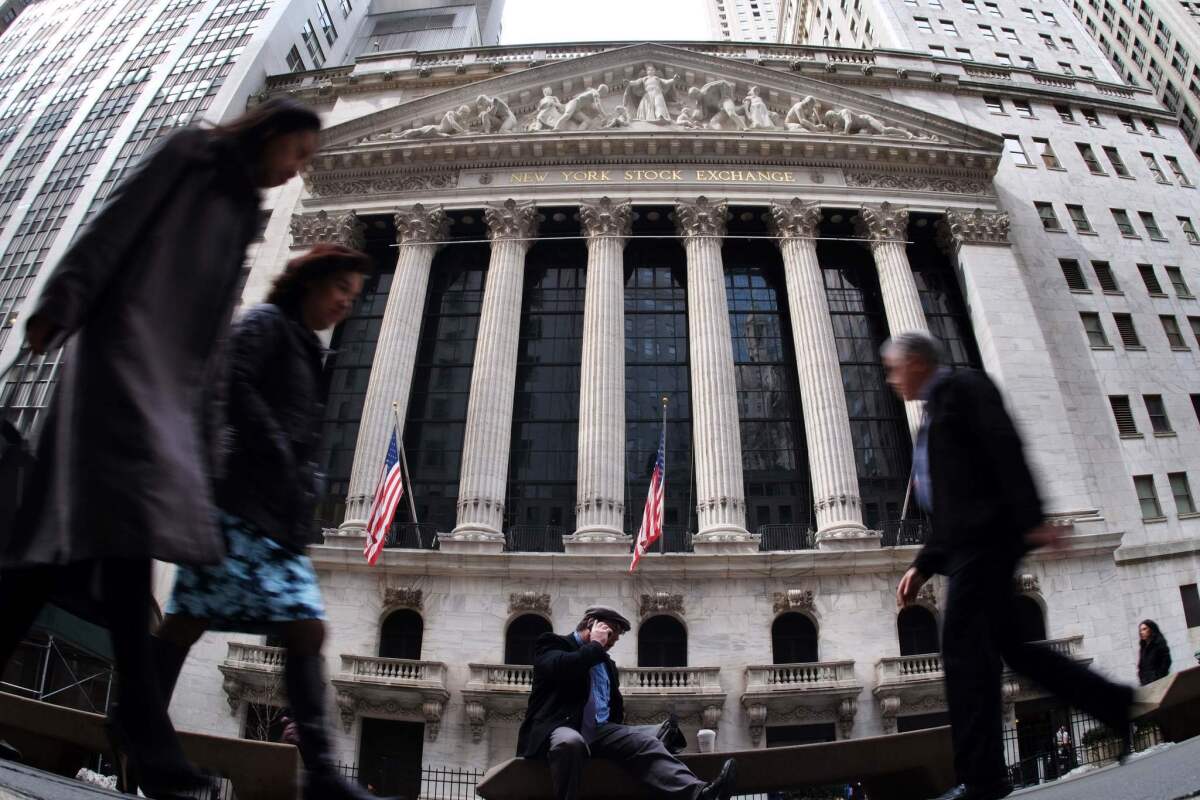 People walk past the New York Stock Exchange.