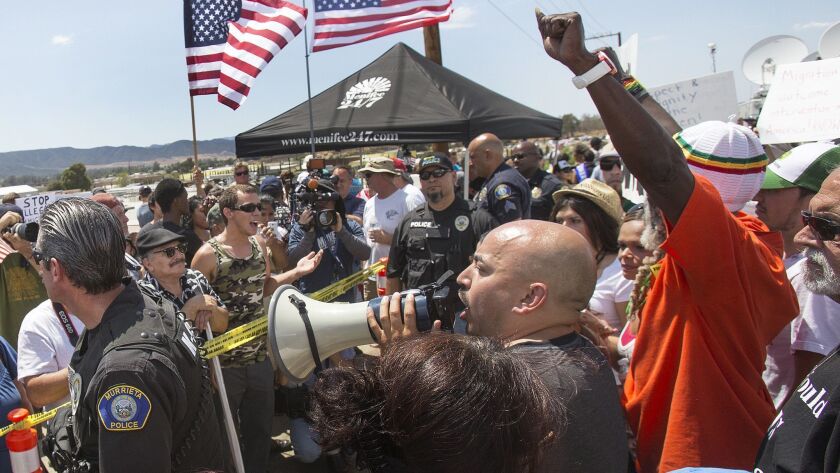 Police stay between opposing groups of protesters outside the Murrieta Border Patrol Detention Center in 2014.