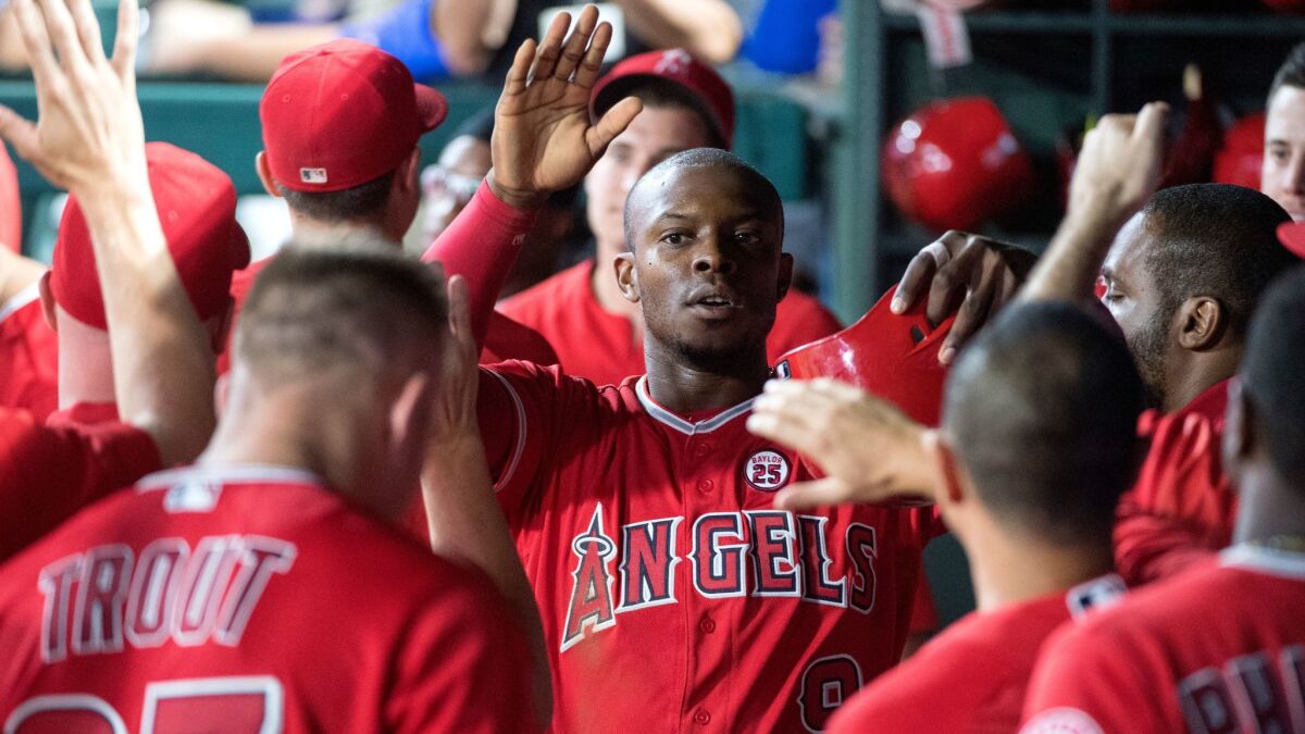 Justin Upton is congratulated by teammates in the dugout after scoring on a single in the 10th inning of a game the Angels would eventually win 7-4 against the Texas Rangers in September in Arlington, Texas.