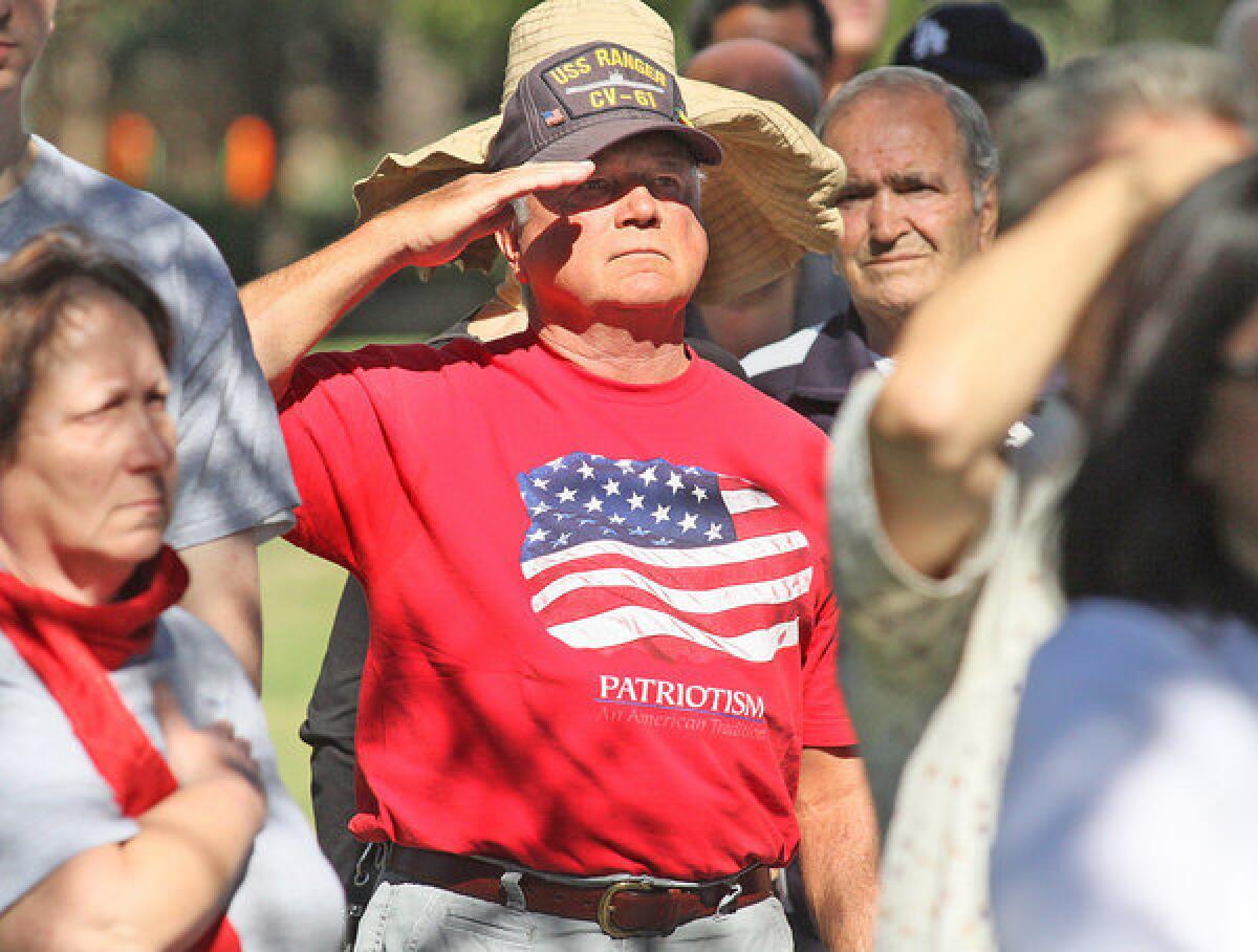Tom Sharp, a former 60 year Burbank resident who lives in and travels in an RV and who served in the Vietnam War on the USS Ranger, salutes the flag during the singing of the Star Spangled Banner at the Veterans Day Ceremony at the McCambridge Park War Memorial in Burbank on Monday, November 11, 2013. (Tim Berger/Staff Photographer)