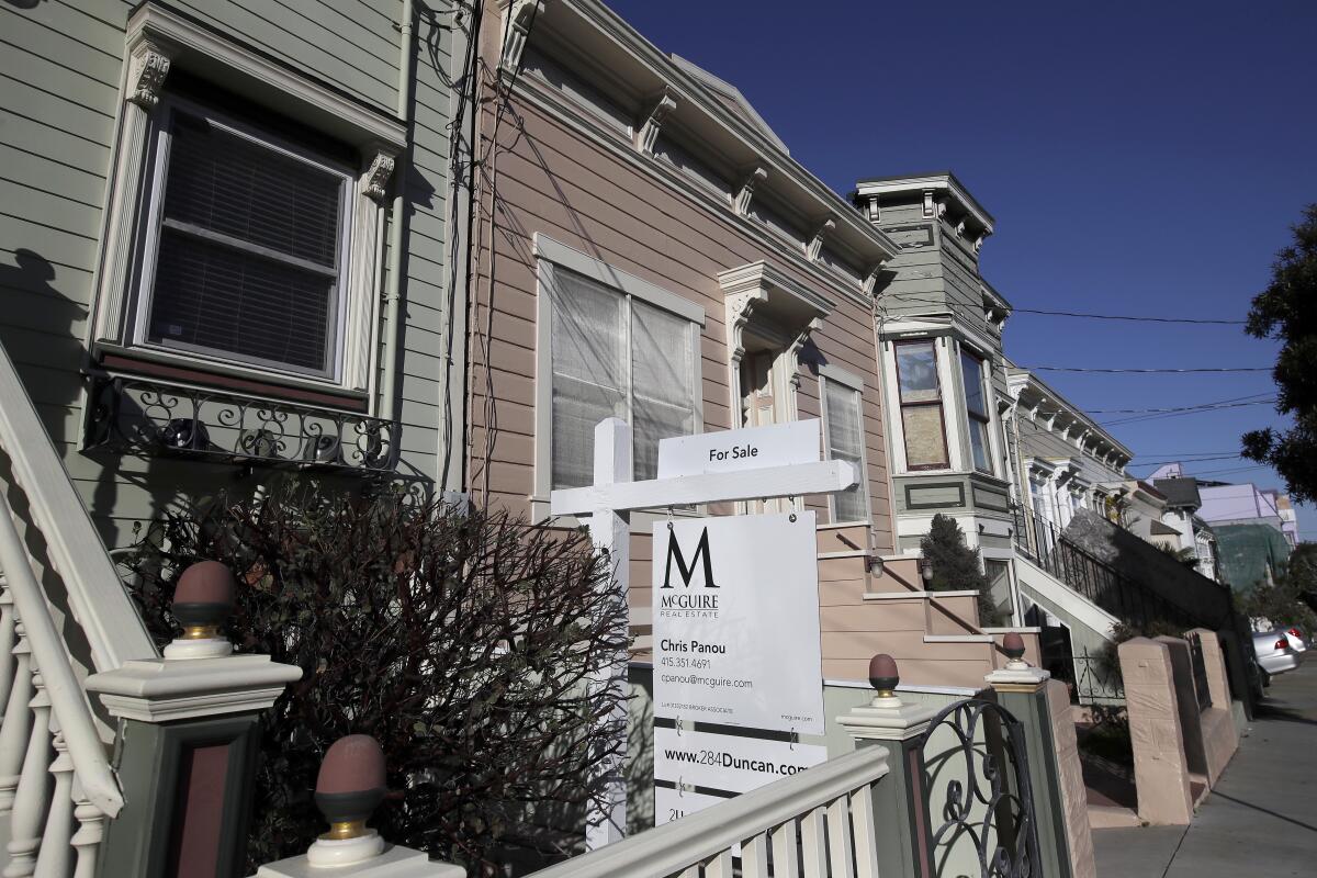 A real estate sign is posted in front of a home for sale in San Francisco on Feb. 18.