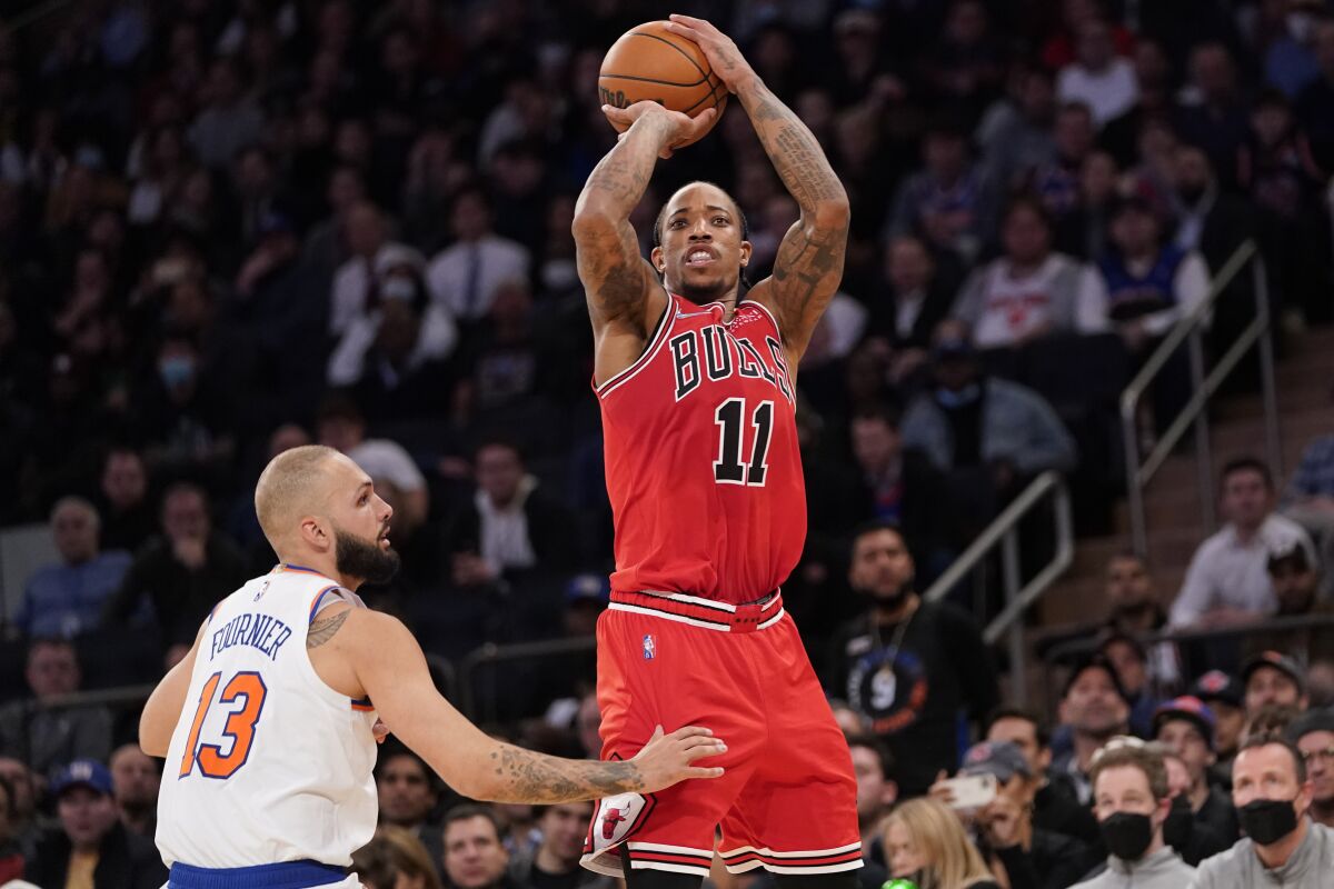 Chicago Bulls forward DeMar DeRozan (11) shoots a three-point basket past New York Knicks guard Evan Fournier (13) in the second half of an NBA basketball game, Thursday, Dec. 2, 2021, at Madison Square Garden in New York. (AP Photo/Mary Altaffer)