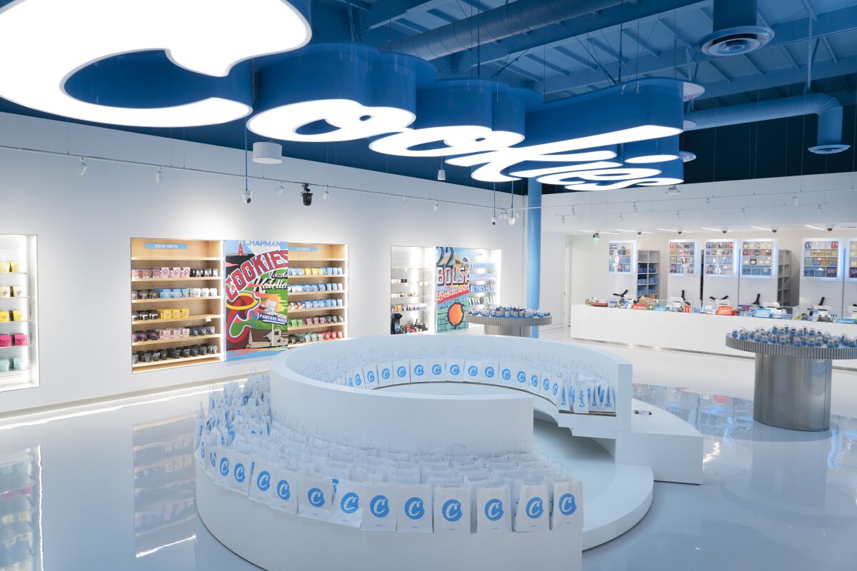 The blue and white interior of a dispensary with a round seating area in the middle.