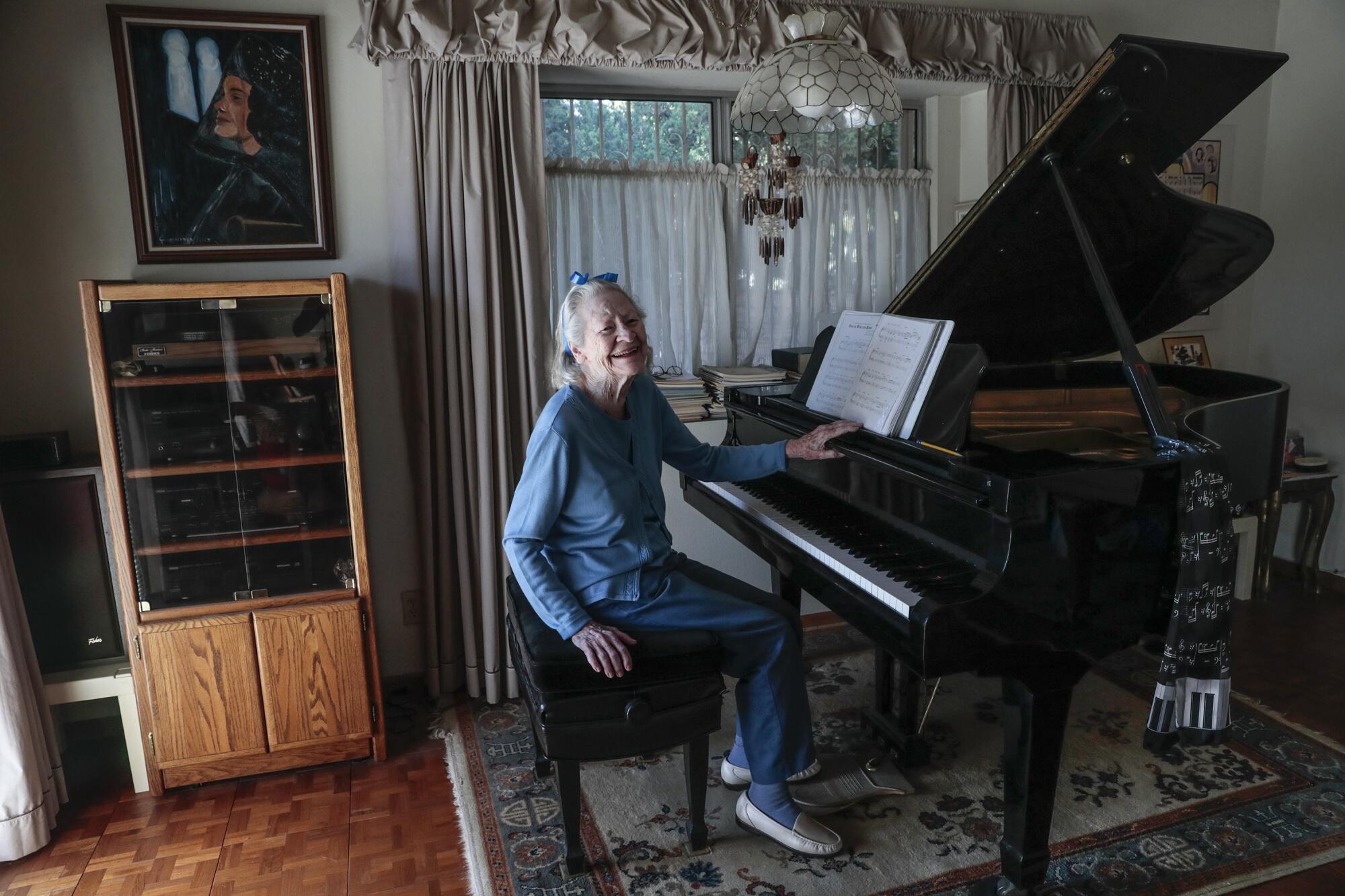 Lois Jones sits at a piano
