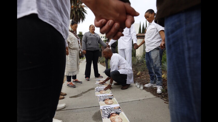 Protesters join hands outside Mayor Eric Garcetti's home early Sunday morning, calling for the mayor to take action over last summer's fatal shooting of Ezell Ford.