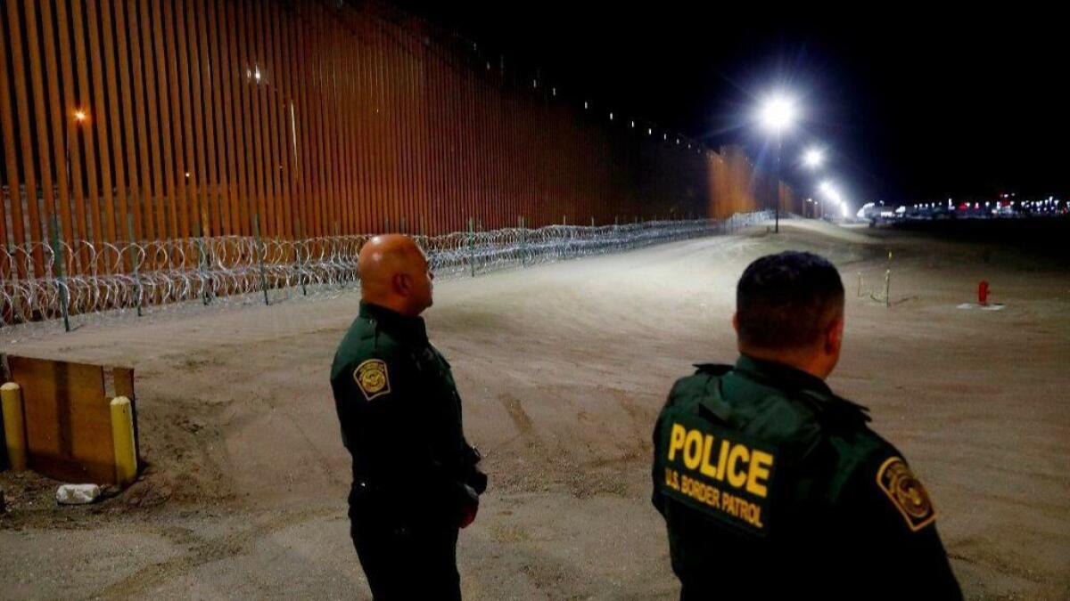 A new border fence with concertina wire straddles the U.S.-Mexico border near Calexico, Calif.