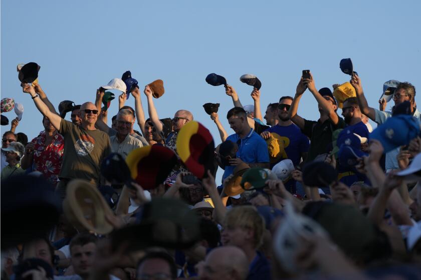 Spectators wave their hats as they watch the afternoon Fourballs matches at the Ryder Cup golf tournament at the Marco Simone Golf Club in Guidonia Montecelio, Italy, Saturday, Sept. 30, 2023. (AP Photo/Alessandra Tarantino)