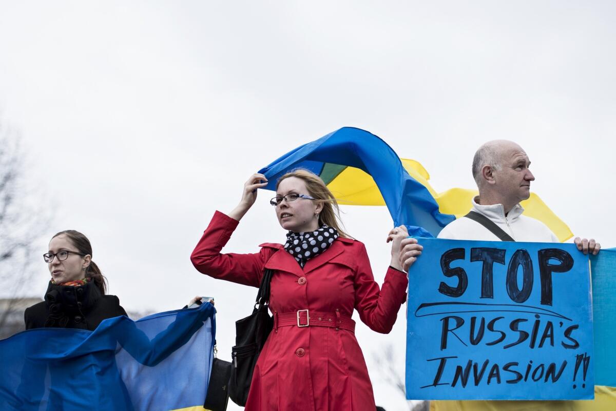Protesters hold flags and signs outside the White House during an anti-Putin protest in Washington, DC ahead of meetings between President Obama and Ukrainian Prime Minister Arseniy Yatsenyuk.
