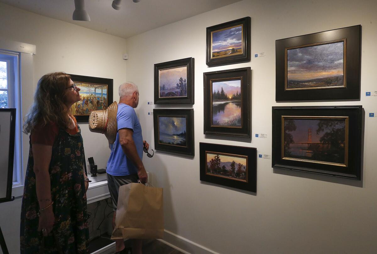 Guests observe the Laguna Plein Air Painters Assn.'s "From Dusk to Dawn" show.