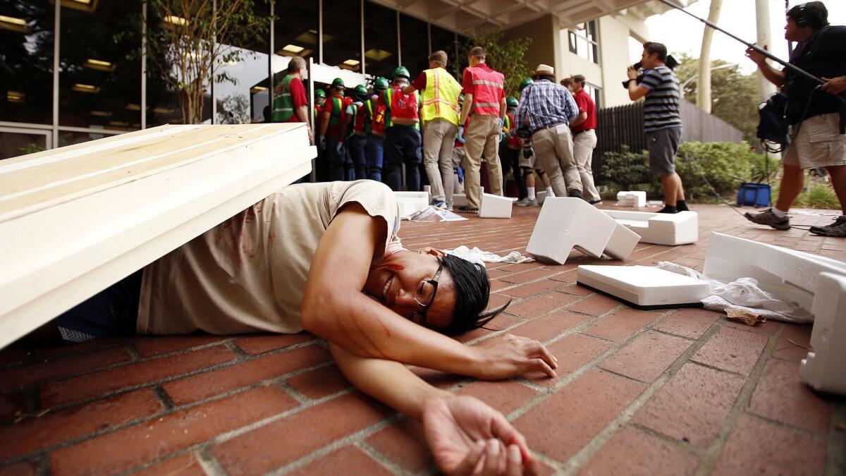 Ghia Simmons, with the USC Army ROTC, plays the part of a quake victim during USC's 2015 ShakeOut drill.