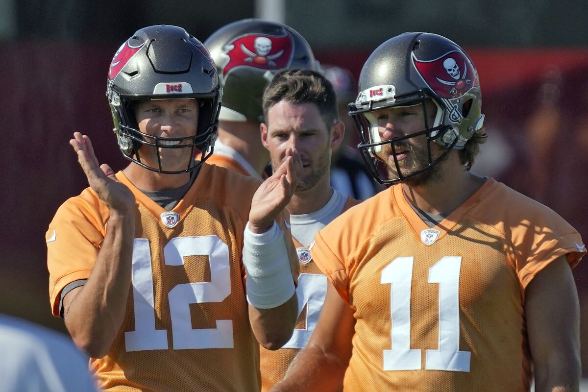 Tampa Bay Buccaneers quarterback Tom Brady (12) claps as he walks with Ryan Griffin (4) and Blaine Gabbert (11) during an NFL football minicamp Wednesday, June 8, 2022, in Tampa, Fla. (AP Photo/Chris O'Meara)