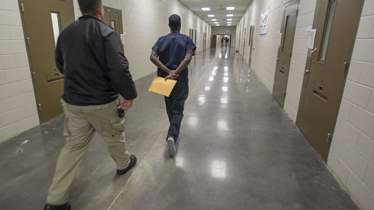 An asylum seeker is escorted by a guard at the Imperial Regional Detention Facility in Calexico, Calif., in January 2017.