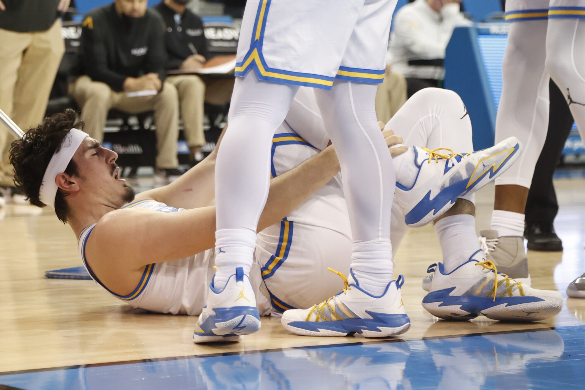 UCLA guard Jaime Jaquez Jr. holds his ankle after tumbling to the court against Long Beach State on Jan. 6.