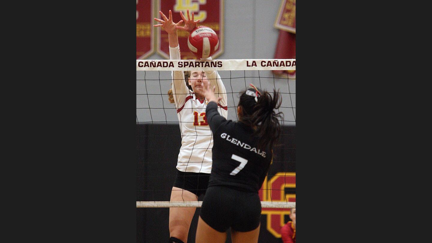 La Canada's Chloe Kerstein blocks a kill by Glendale's Leila Manaois in a non-league girls' volleyball match at La Cañada High School on Tuesday, August 22, 2017. La Cañada won the match 3-0.